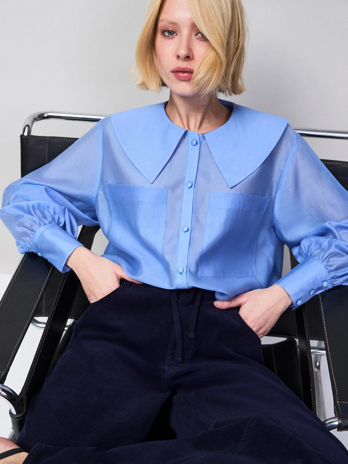 Blue sheer blouse with oversized collar, button fastening and front pocket detail