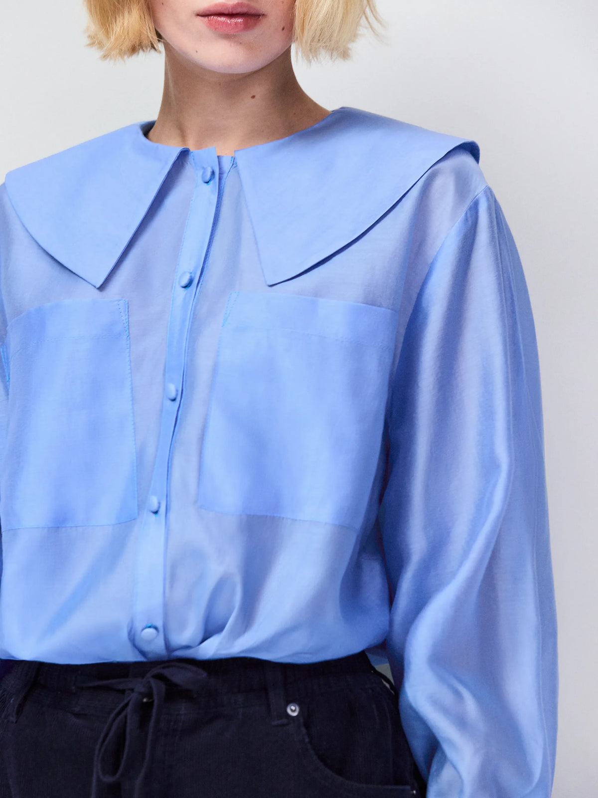 Women’s blue sheer blouse featuring statement collar and deep cuff detailing