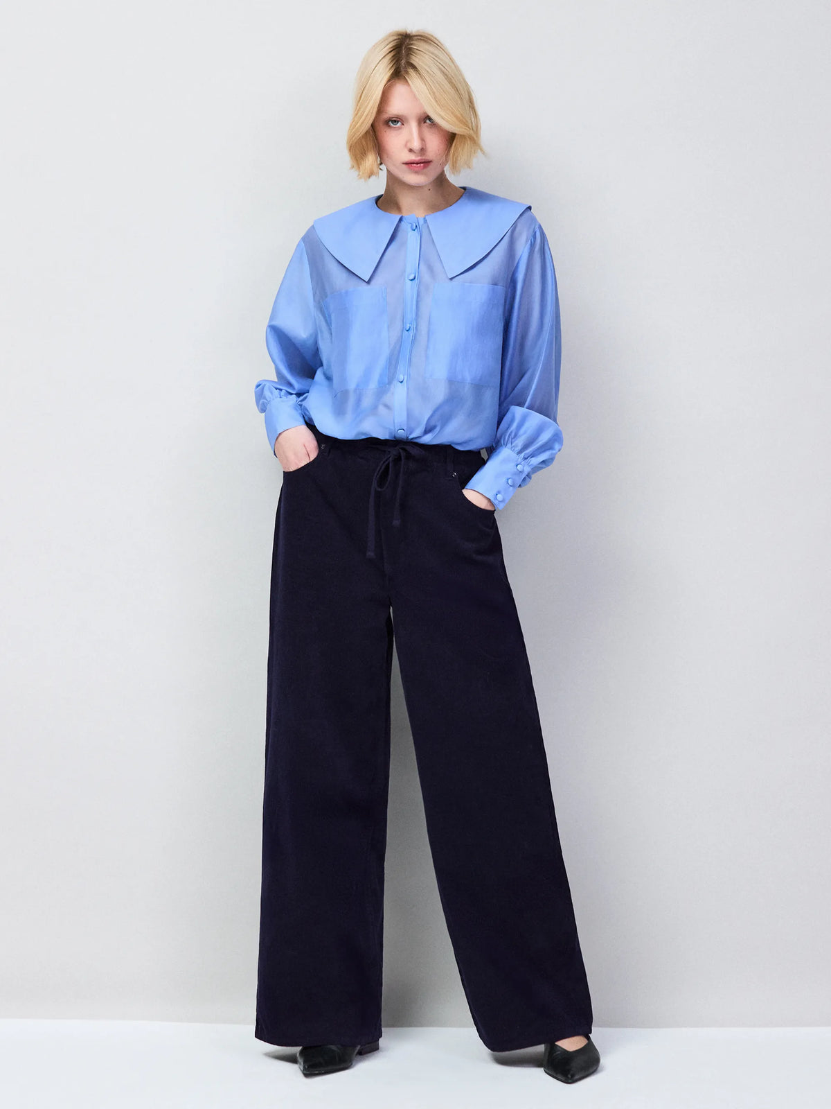 Light blue unlined sheer blouse with button front and chest pocket detail