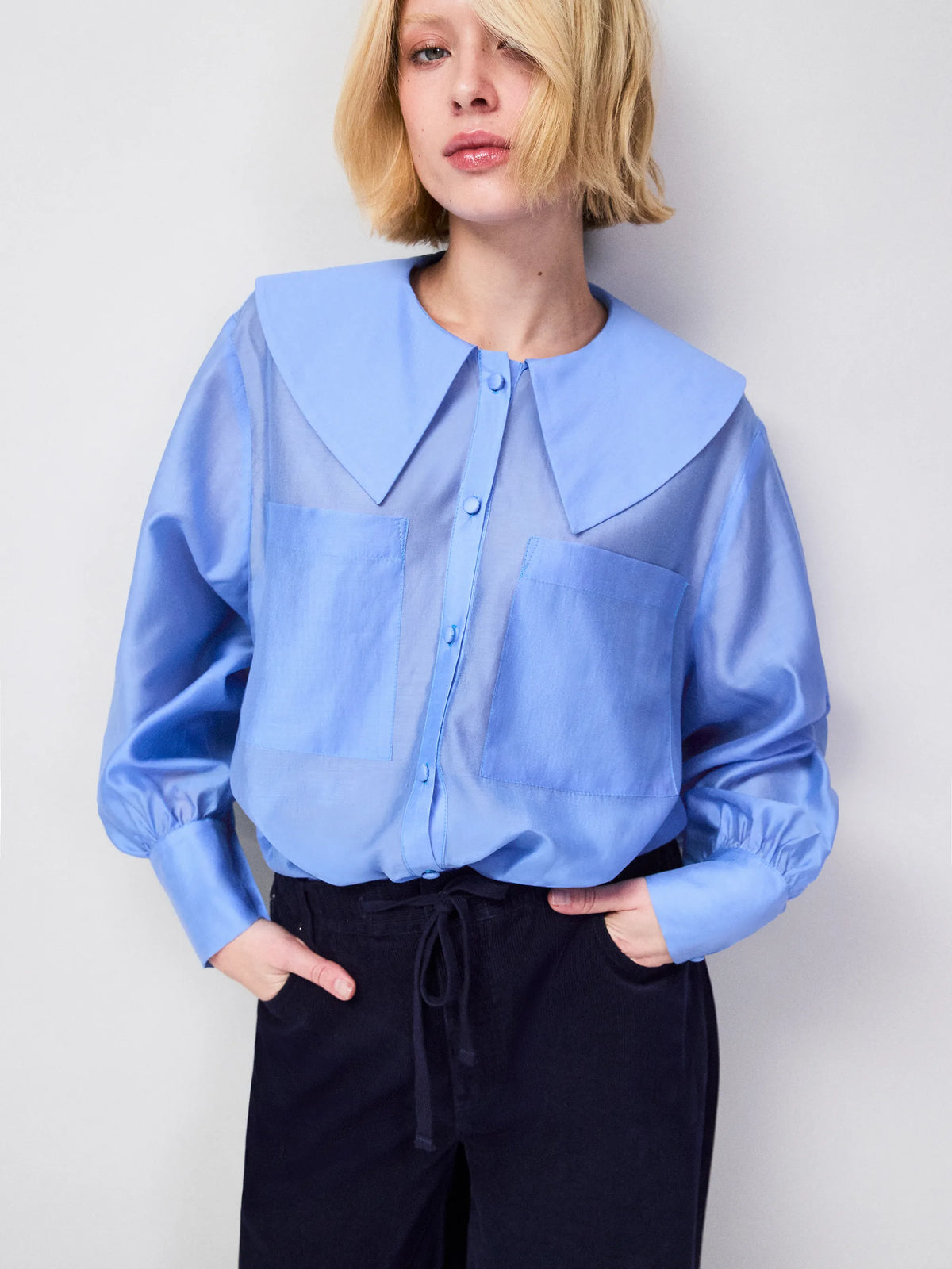 Blue semi-sheer blouse with oversized pointed collar and structured deep cuffs