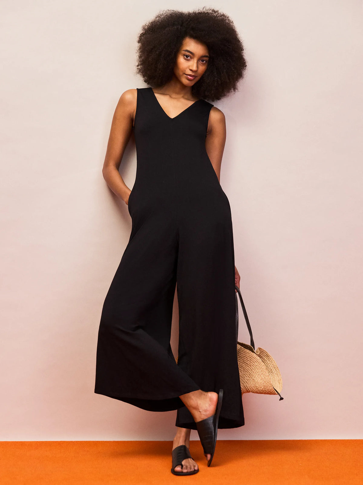 Black V neck jersey jumpsuit with wide leg silhouette and sleeveless design