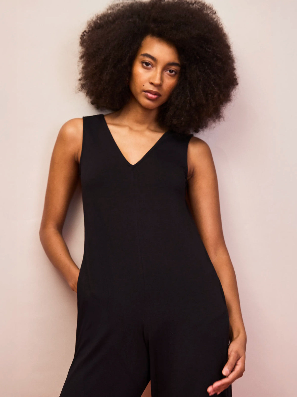 Sleeveless black jersey jumpsuit with deep V neckline and full length wide legs